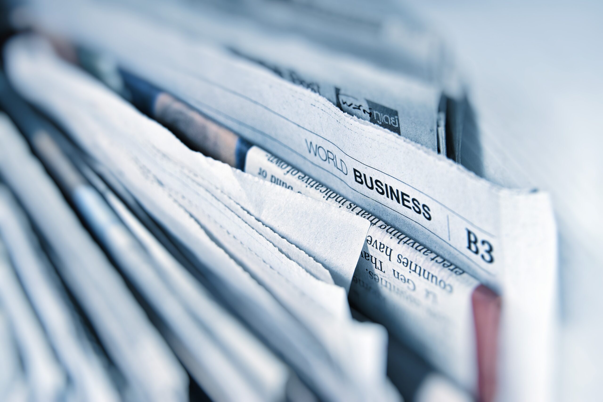 Services 3 Stack of newspapers with visible WORLD BUSINESS B3 section.