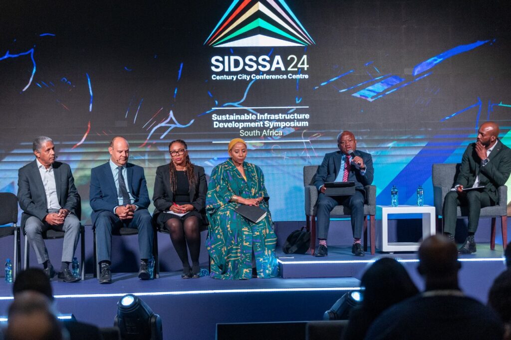 Panel discussion at SIDSSA24 conference with six speakers on stage.