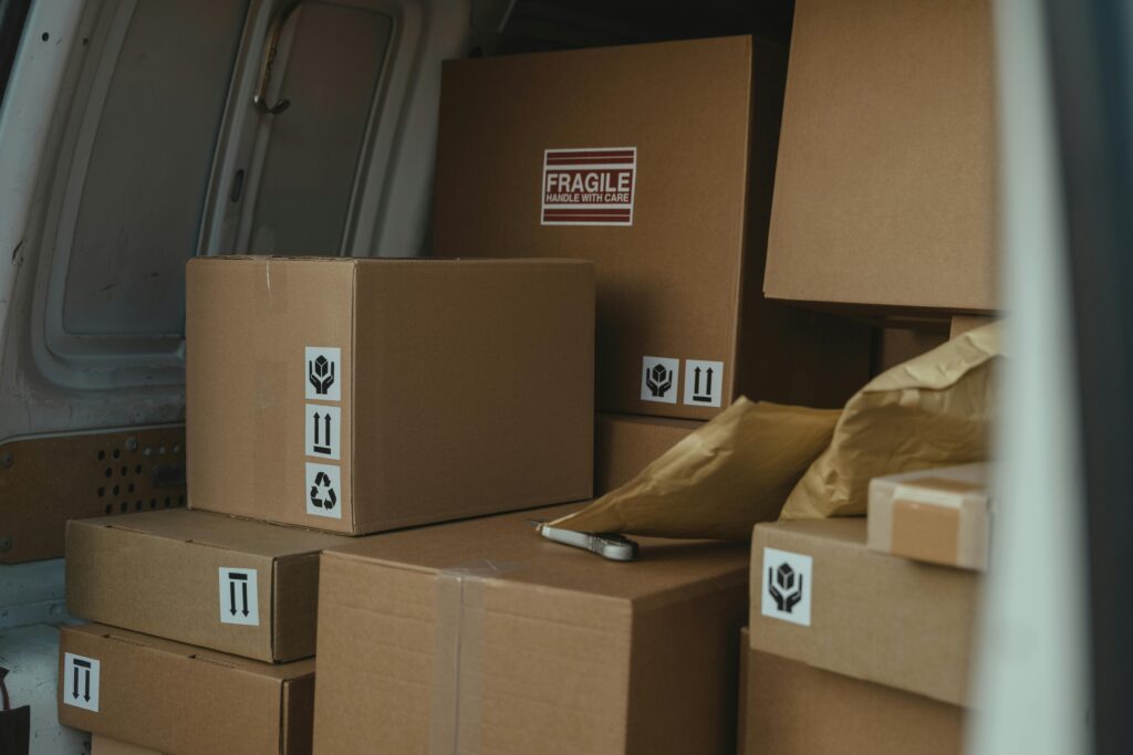 Interior of delivery van filled with cardboard boxes and padded envelopes.
